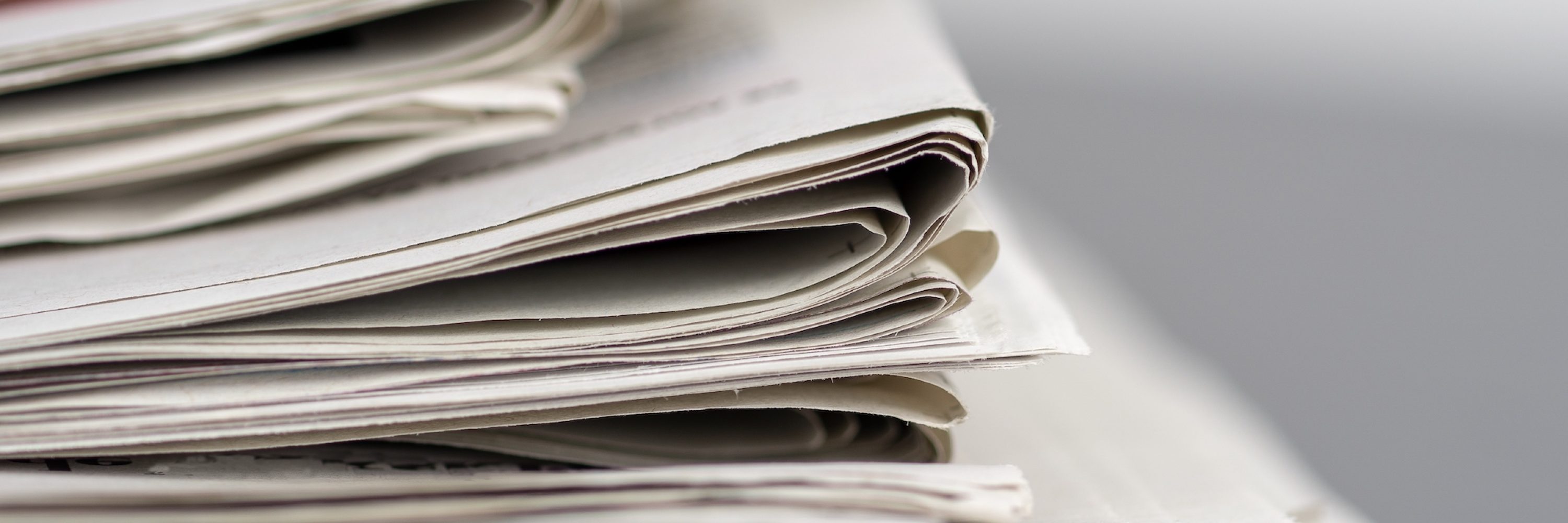 A closeup shot of several newspapers stacked on top of each other